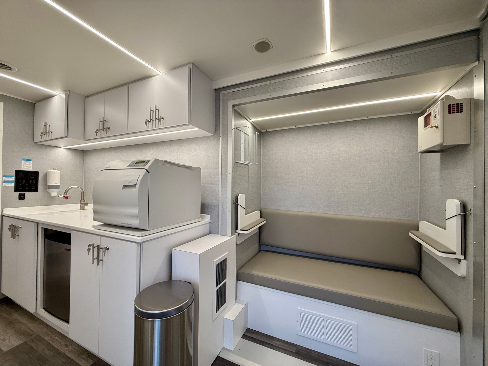 Sterilization center beside bench seating with fold-down worksurfaces