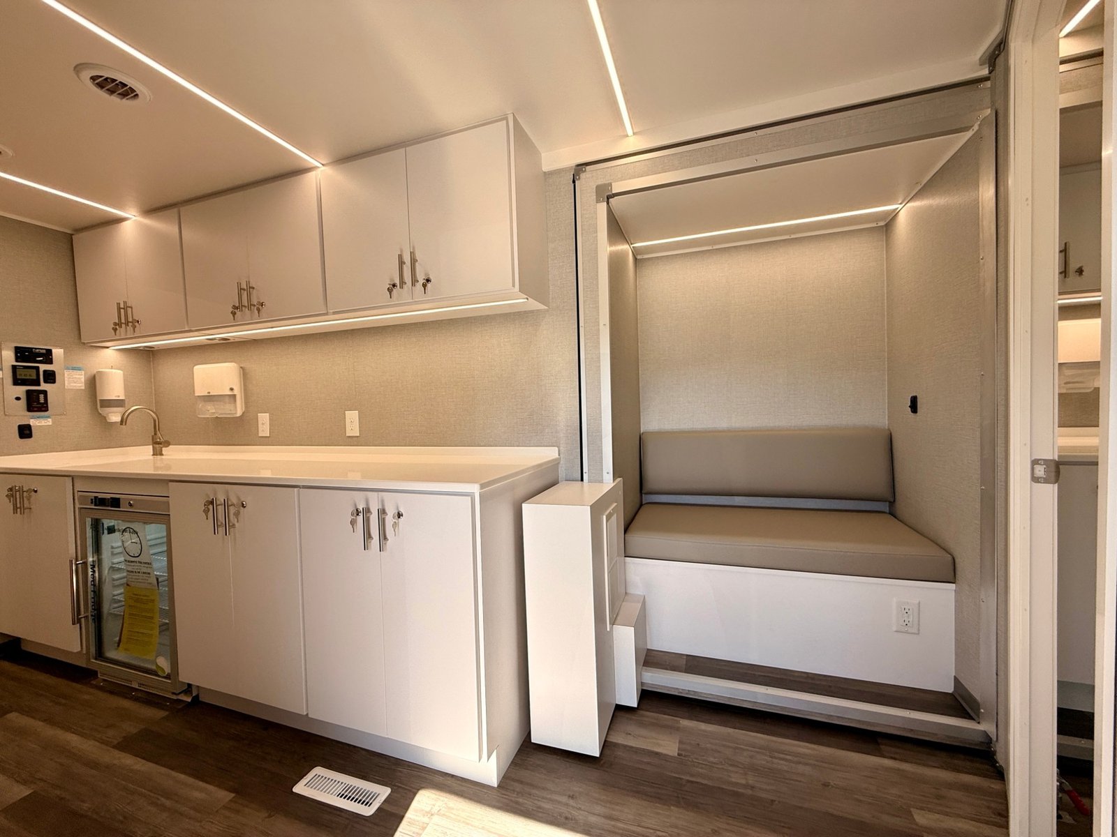 Galley with med-fridge, locking cabinetry, and fold-out bench seating