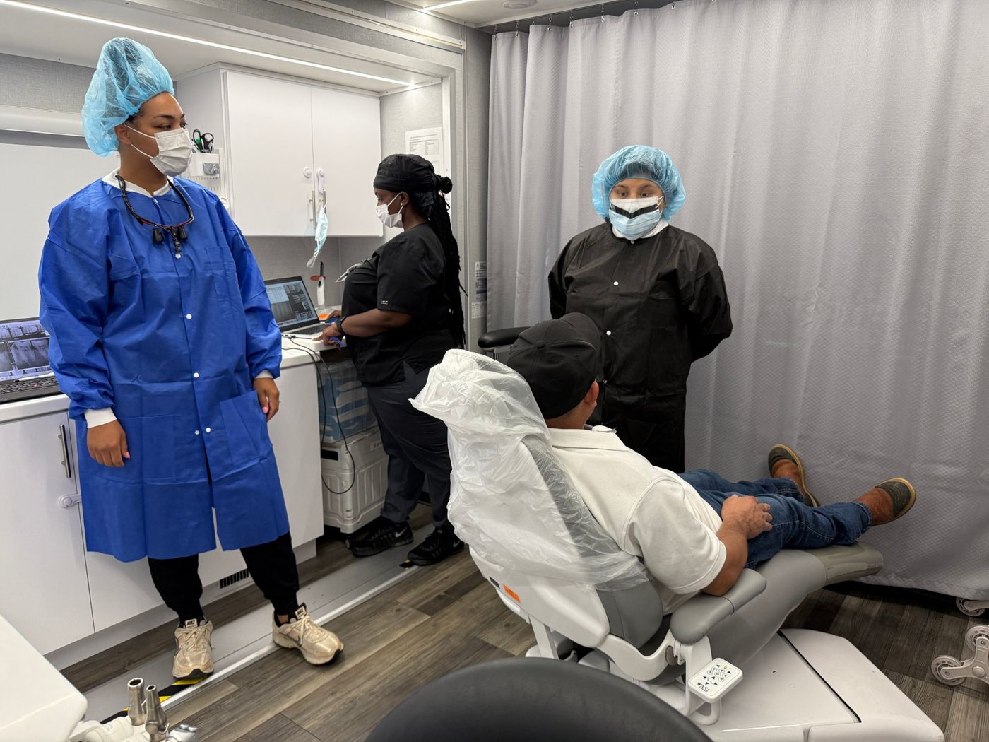 Dental team treating a patient inside a mobile dental clinic