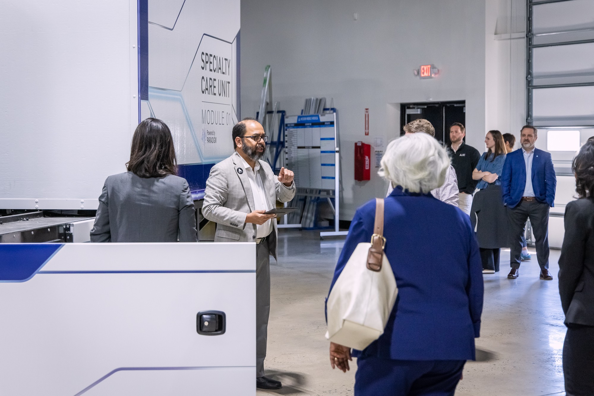 A team member walking visitors around the Specialty Care Unit Module 01 on the shop floor