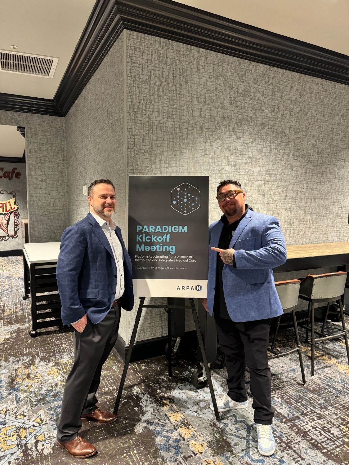 Team members beside the PARADIGM Kickoff Meeting sign in New Orleans